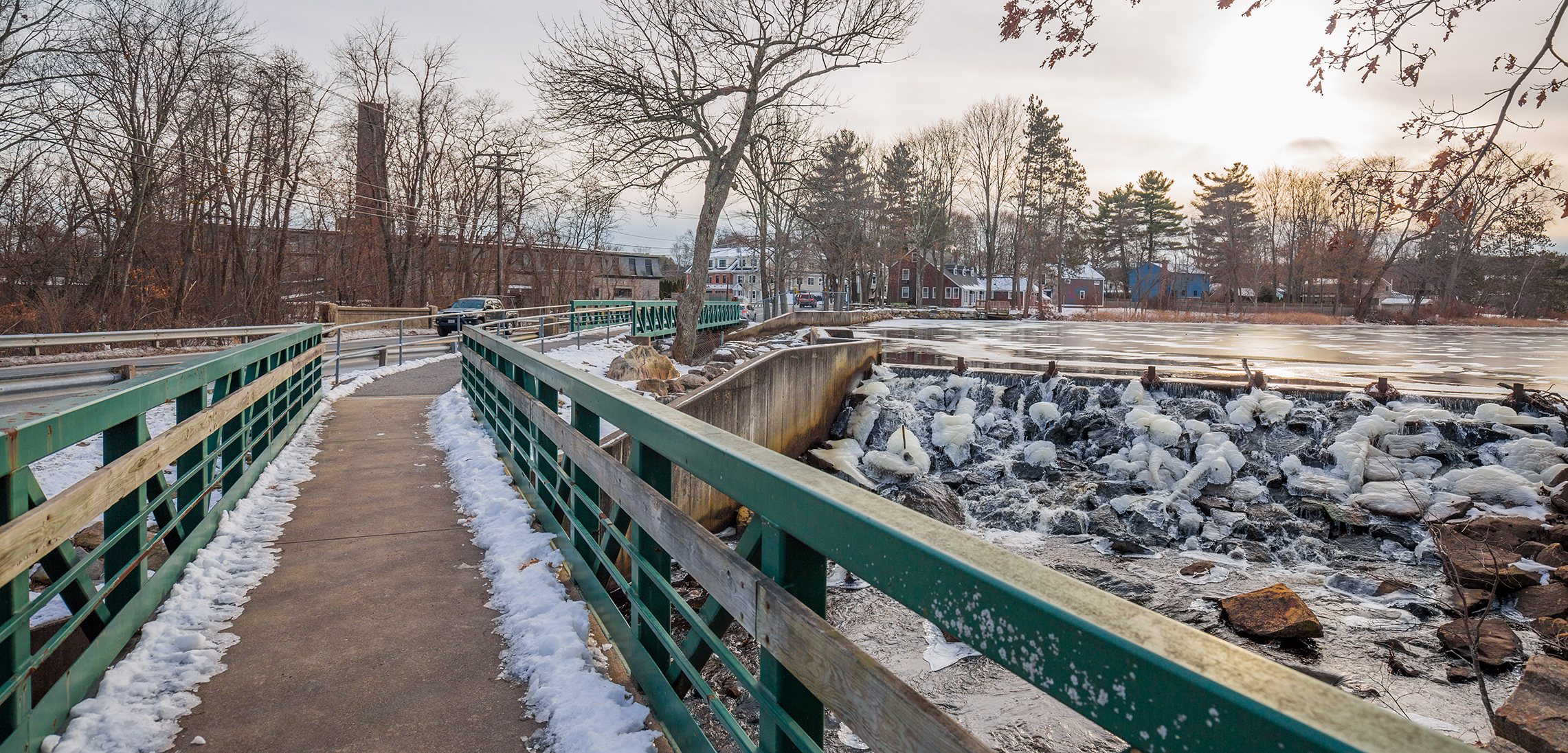 Pedestrian bridge over Mill Pond Park, Ashland, offering serene views of Sudbury River.